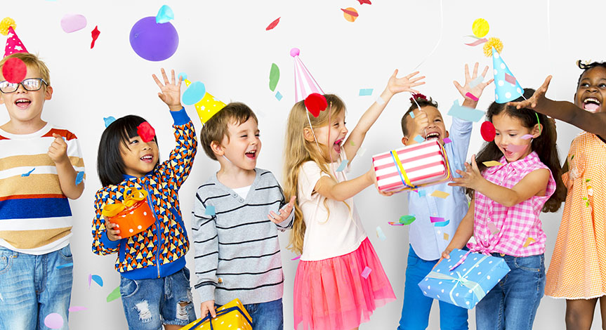 Group of kids celebrate birthday party together with presents, confetti and balloons